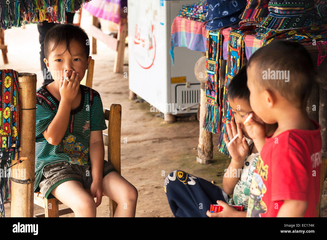 Young Chinese boys pretending to smoke with candy sticks in Guangxi Province, China Stock Photo