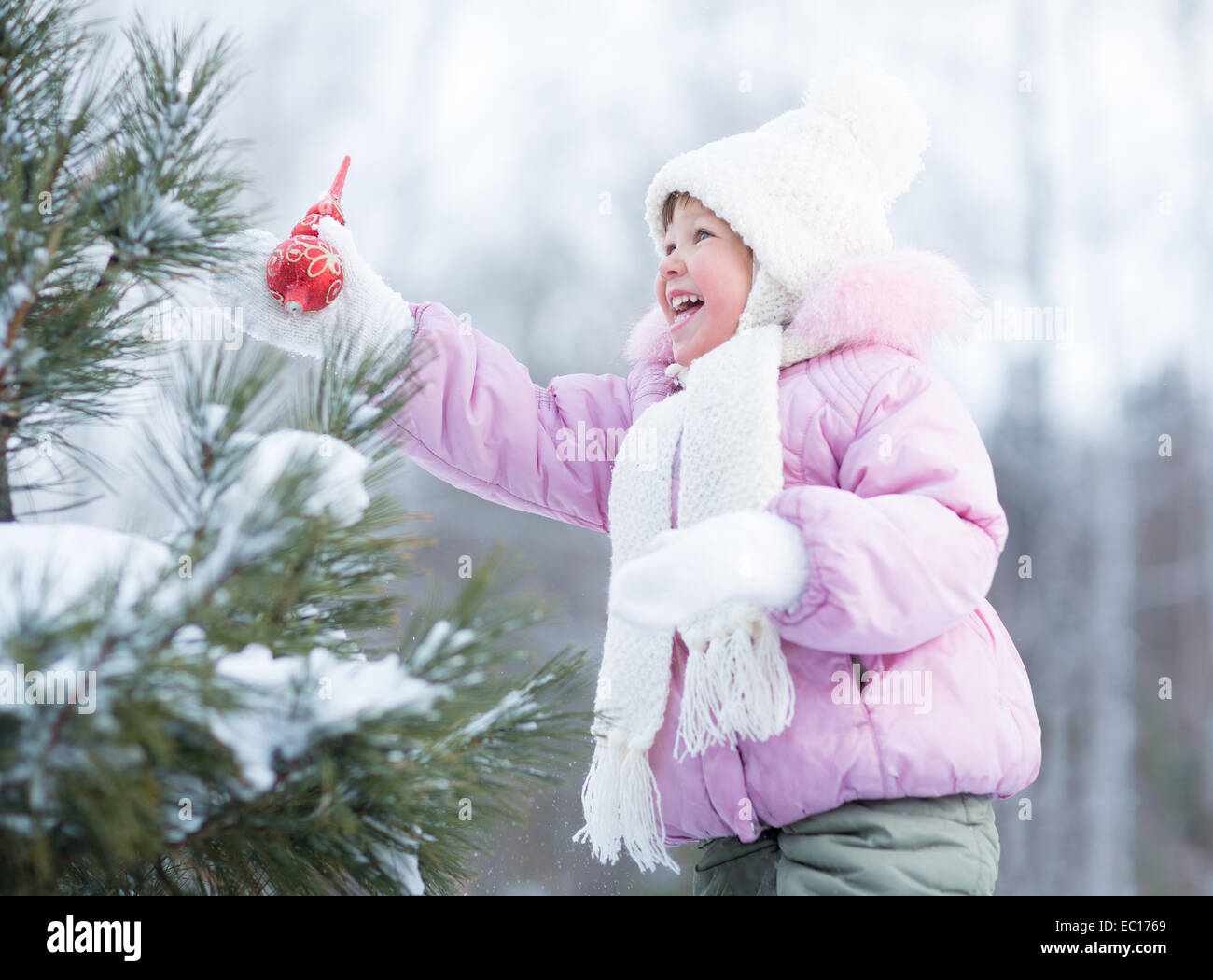 Happy kid making christmas tree decorations outdoor Stock Photo