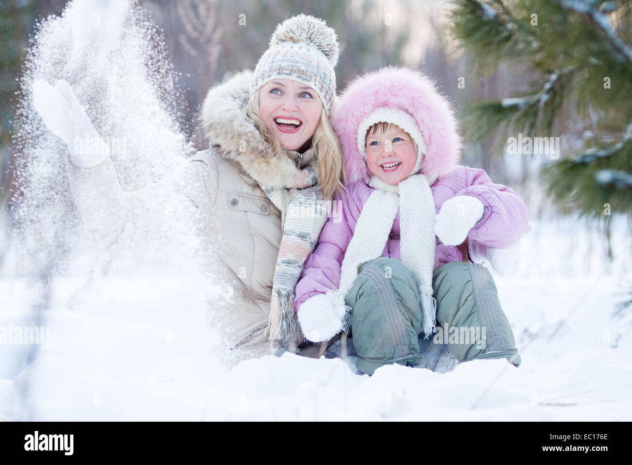 Happy parent and kid playing with snow in winter outdoor Stock Photo