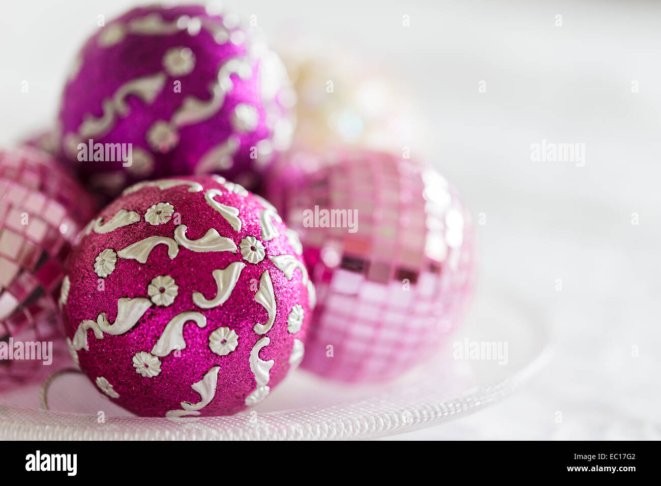 Pink and purple Christmas decorations on a glass plate Stock Photo