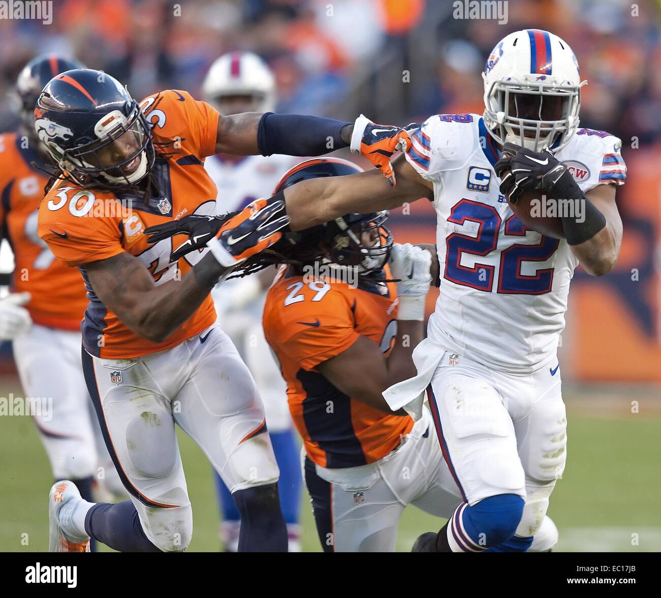 Denver, Colorado, USA. 7th Dec, 2014. Bills RB FRED JACKSON, right, runs for tough yardage through Broncos S DAVID BRUTON JR., left, and CB BRADLEY ROBY, center, during the 2nd. Half at Sports Authority Field at Mile High Sunday afternoon. The Broncos beat the Bills 24-17. Credit:  Hector Acevedo/ZUMA Wire/Alamy Live News Stock Photo