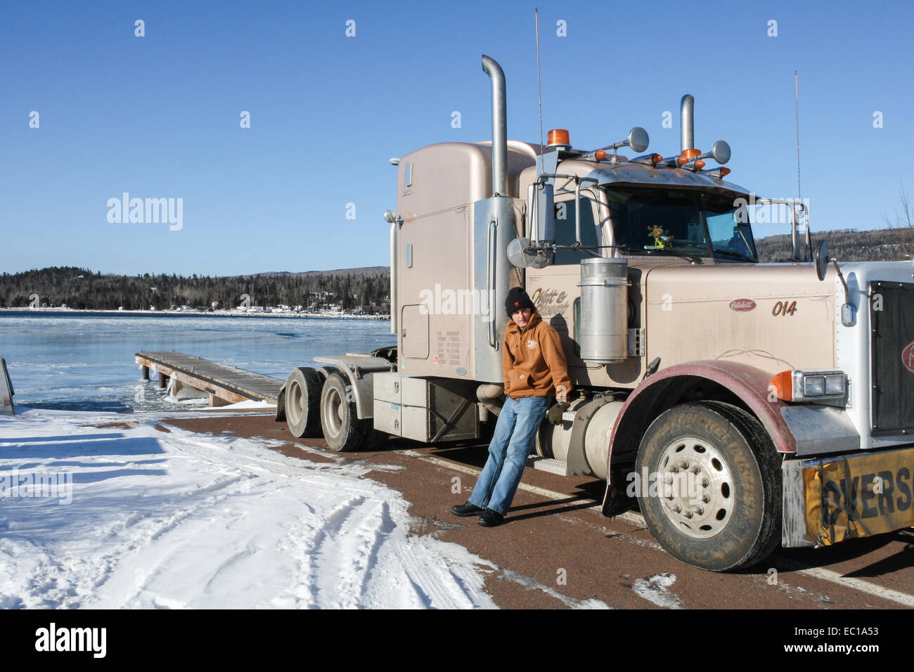 Grand Marais, Minnesota, United States. The frozen bay with a semi truck driver and Peterbilt 379 tractor parked on the jetty. Stock Photo