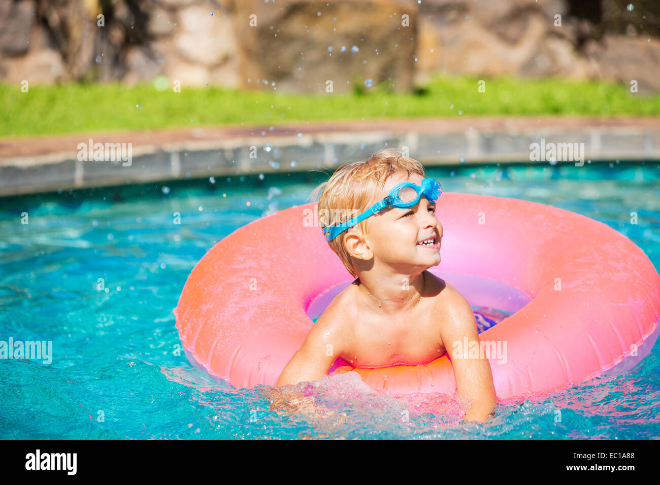 Little Kid Having Fun in Swimming Pool, with Goggles and Raft. Summer