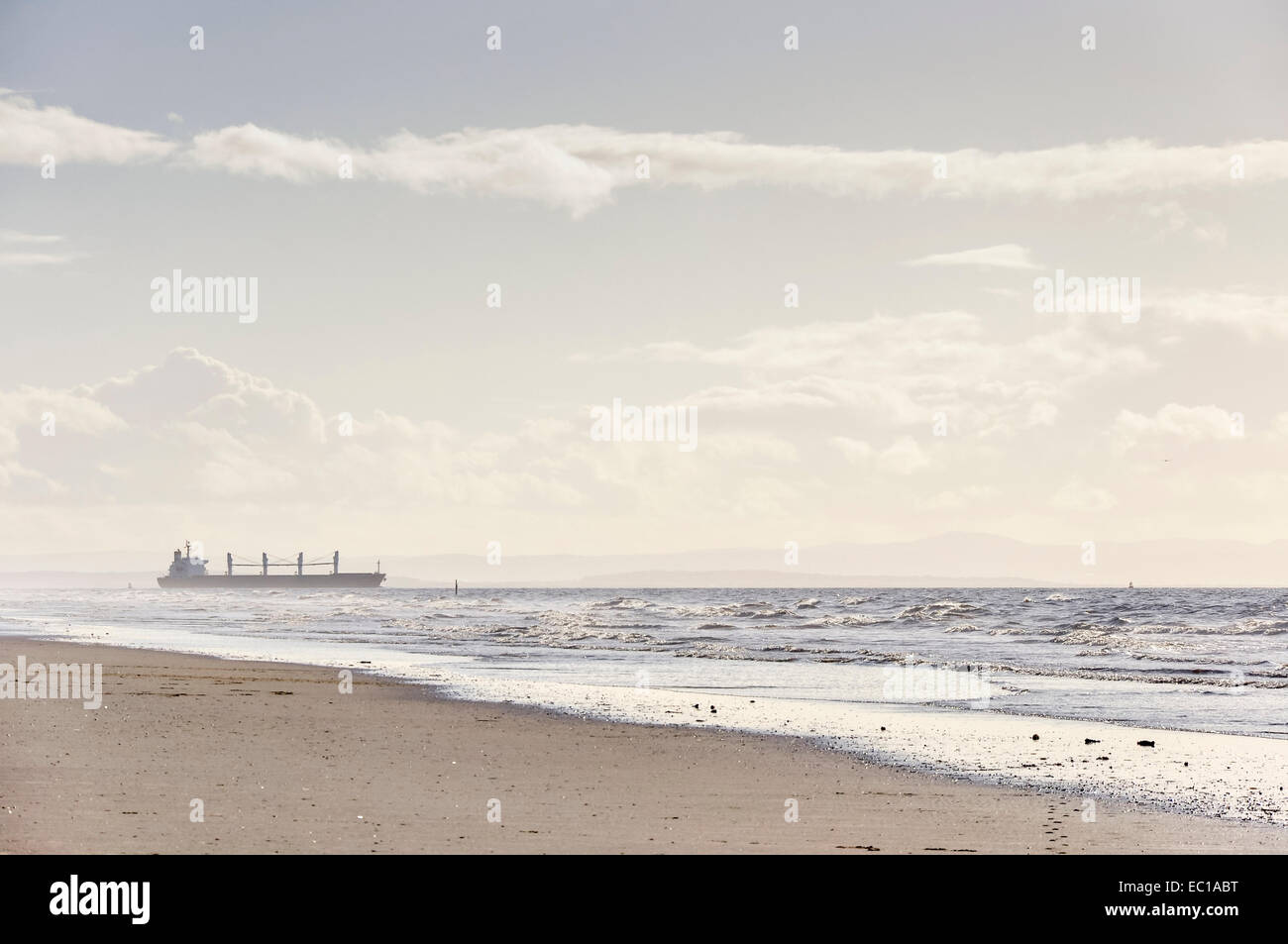 Cargo ship seen from Formby Point in Merseyside leaving Liverpool and heading out to sea. Stock Photo