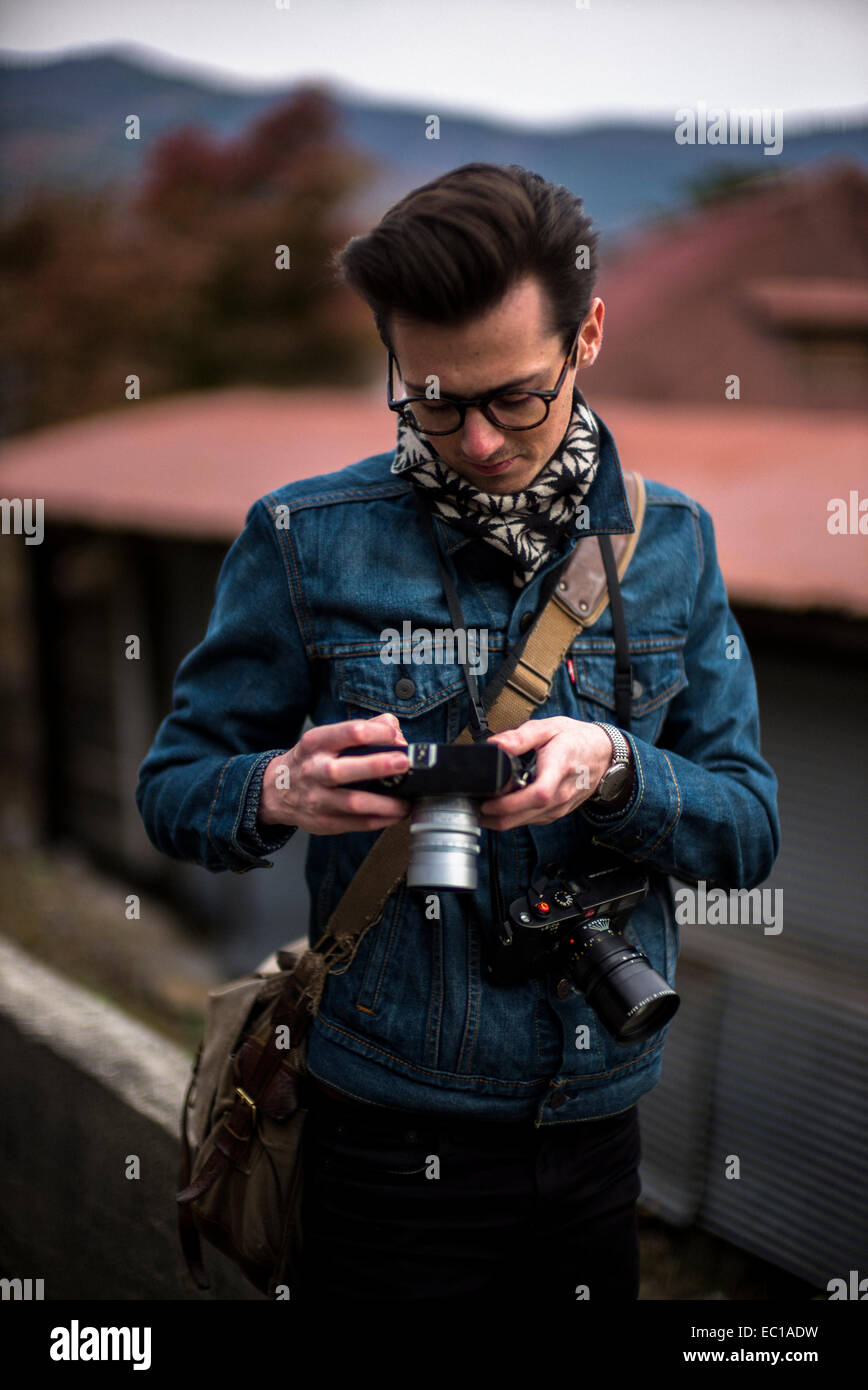 Young male photographer checking his images. Stock Photo