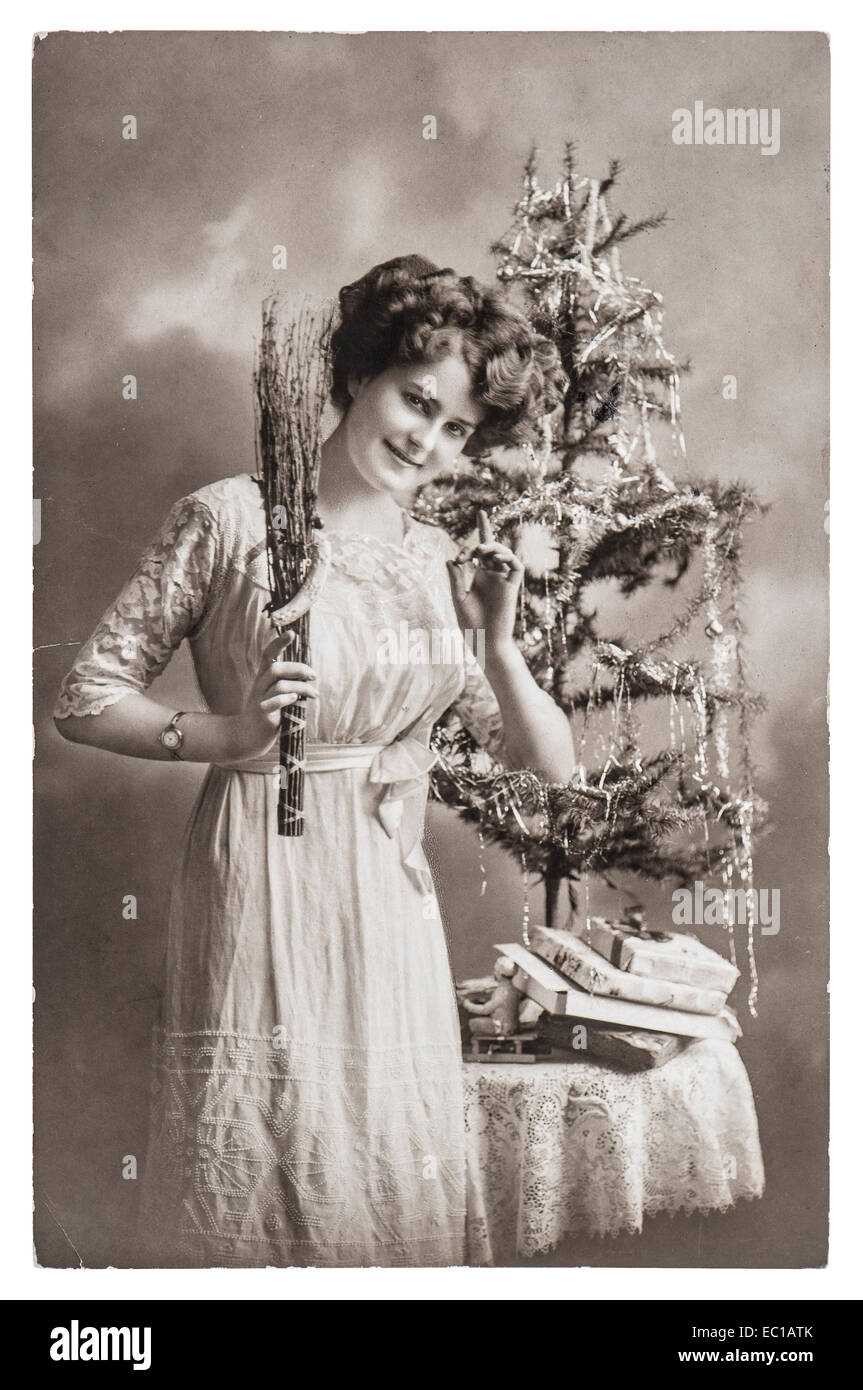 young woman with christmas tree and gifts. antique picture with original scratches and film grain Stock Photo