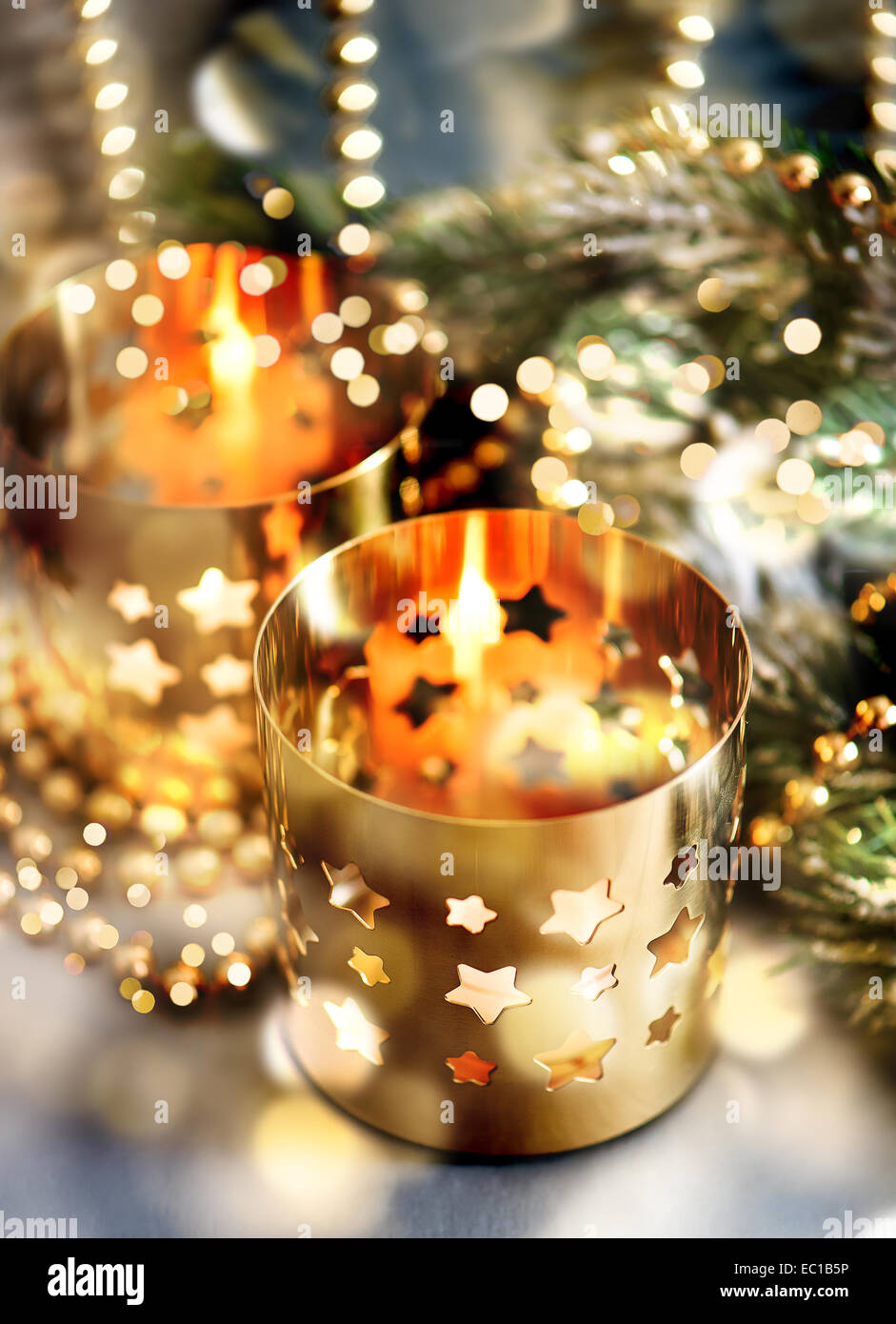 christmas decoration with burning candles, lanterns and golden lights