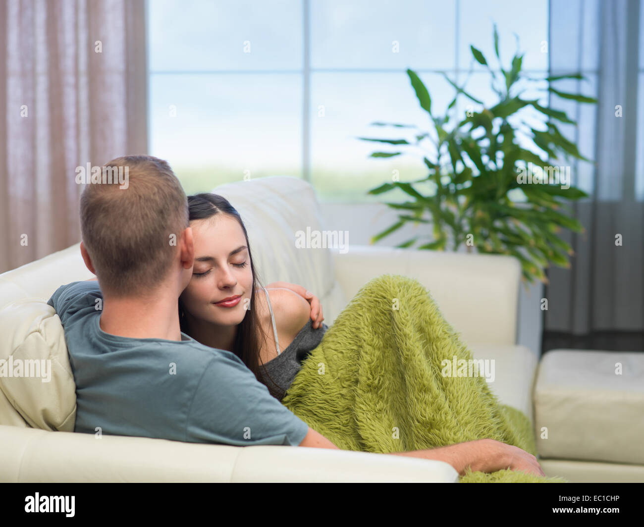 young caucasian couple in love sitting on sofa at home Stock Photo - Alamy