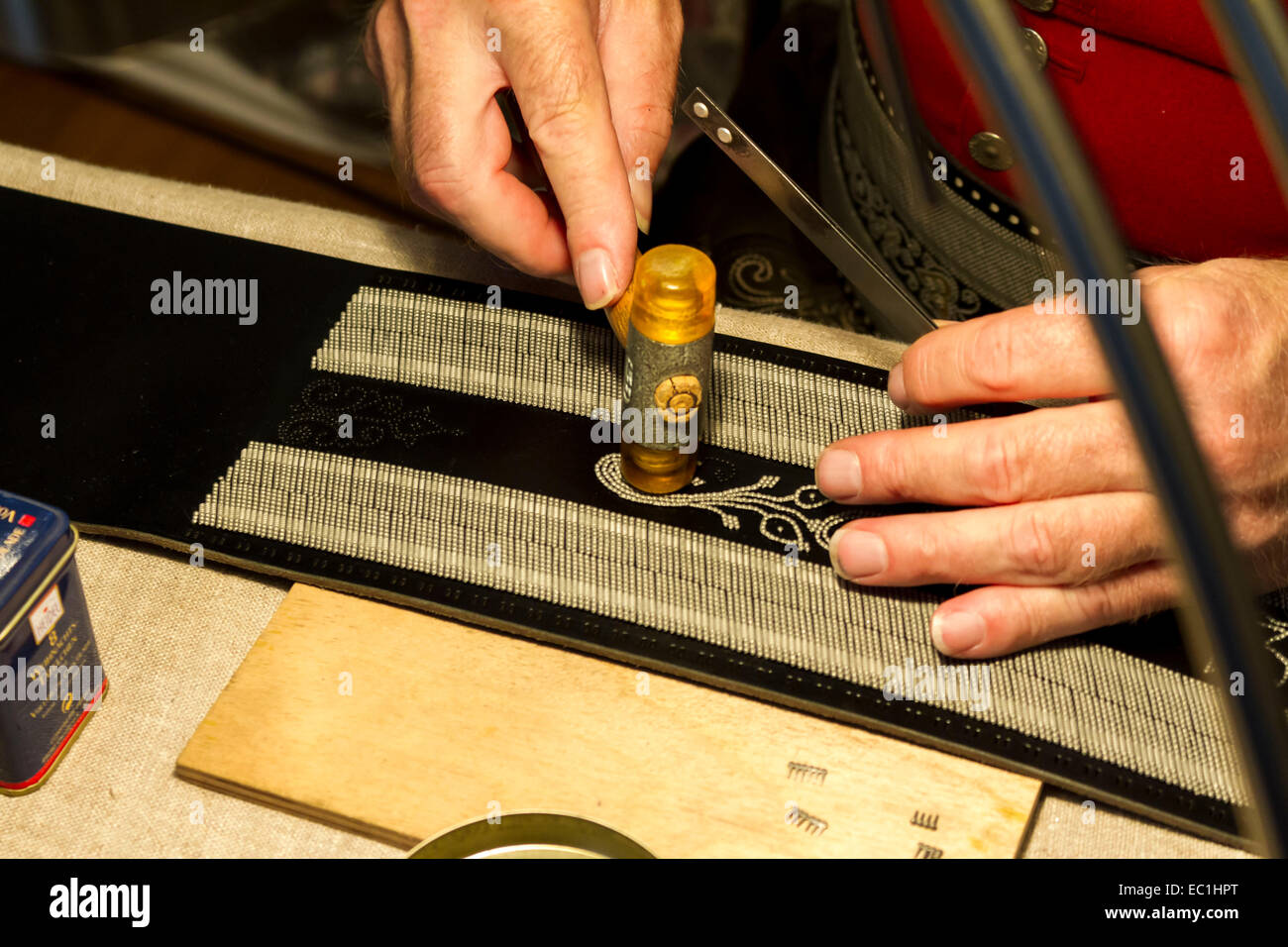 Craftsman placing pins into  a Bavarian leather belt, Prien, Chiemgau, Upper Bavaria, Germany, Deutschland, Europe. Stock Photo