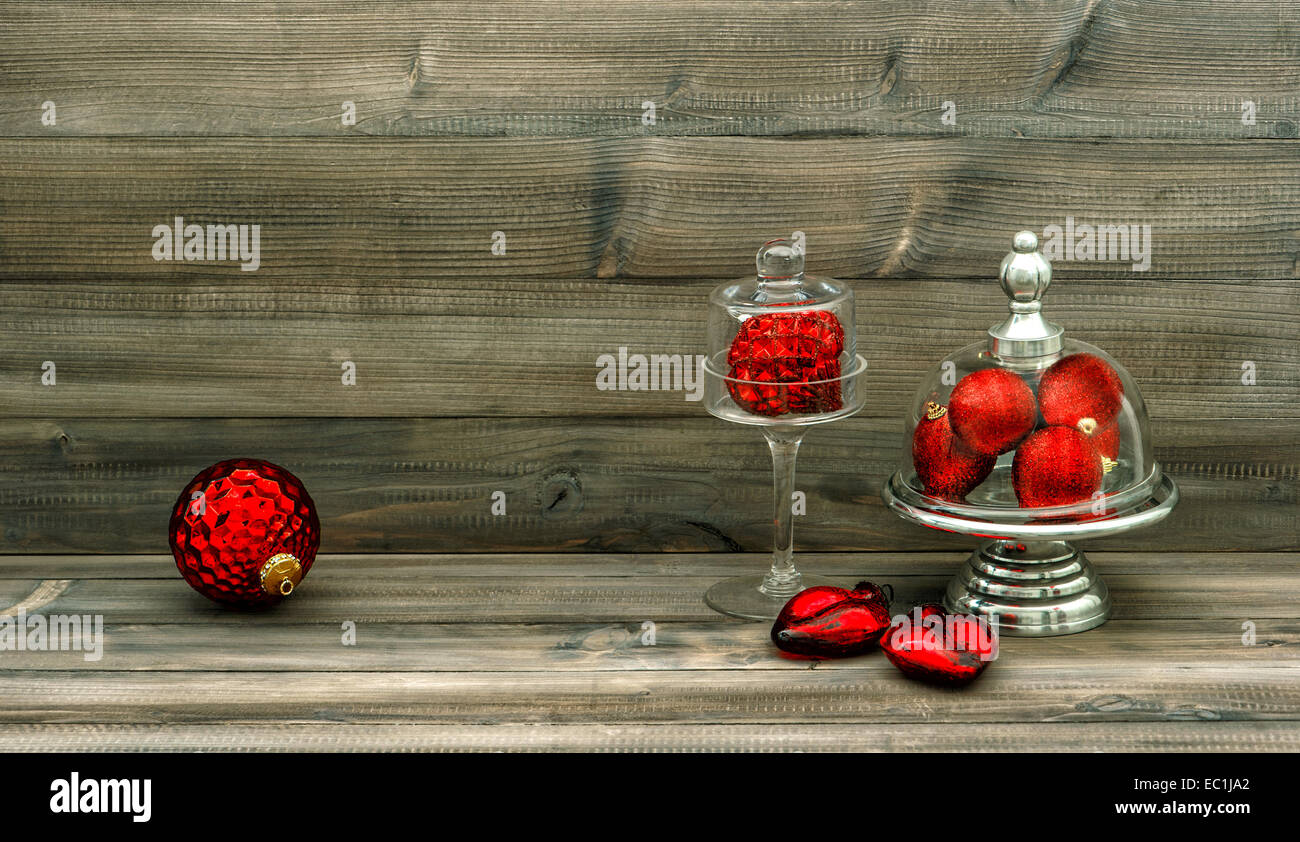 christmas decoration with red baubles on rustic wooden background. nostalgic home interior. retro style toned picture Stock Photo