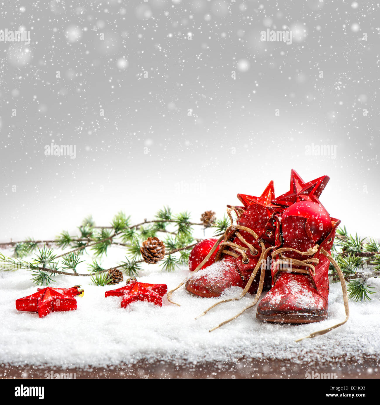 nostalgic christmas decoration with antique baby shoes. retro style picture with falling snow effect Stock Photo
