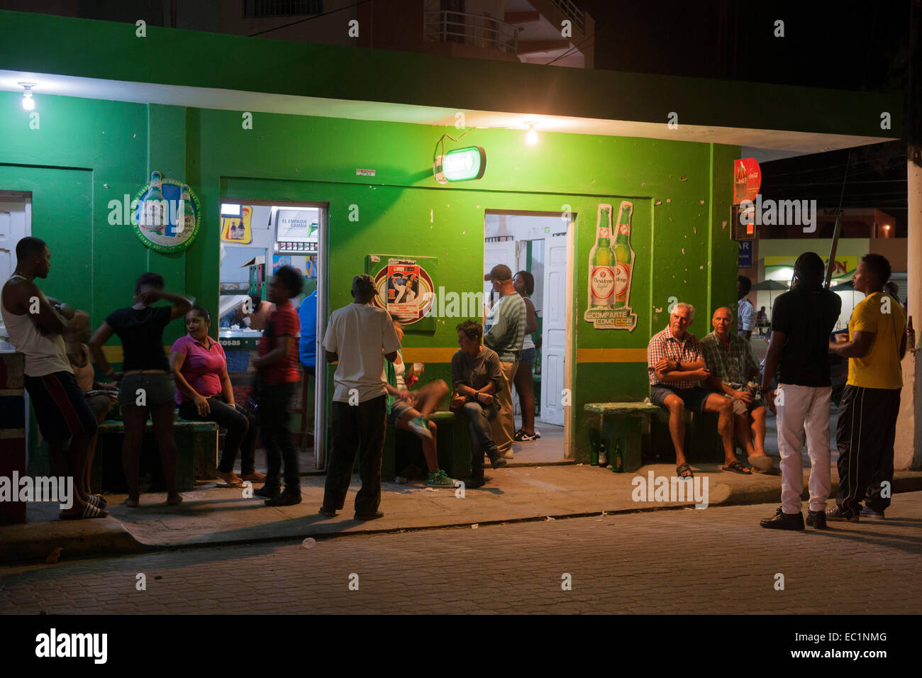 Dominikanische Republik, Osten, Bayahibe, Treffpunkt für Touristen und Einheimische am Abend: der Colmado (kleines Geschäft) in Stock Photo