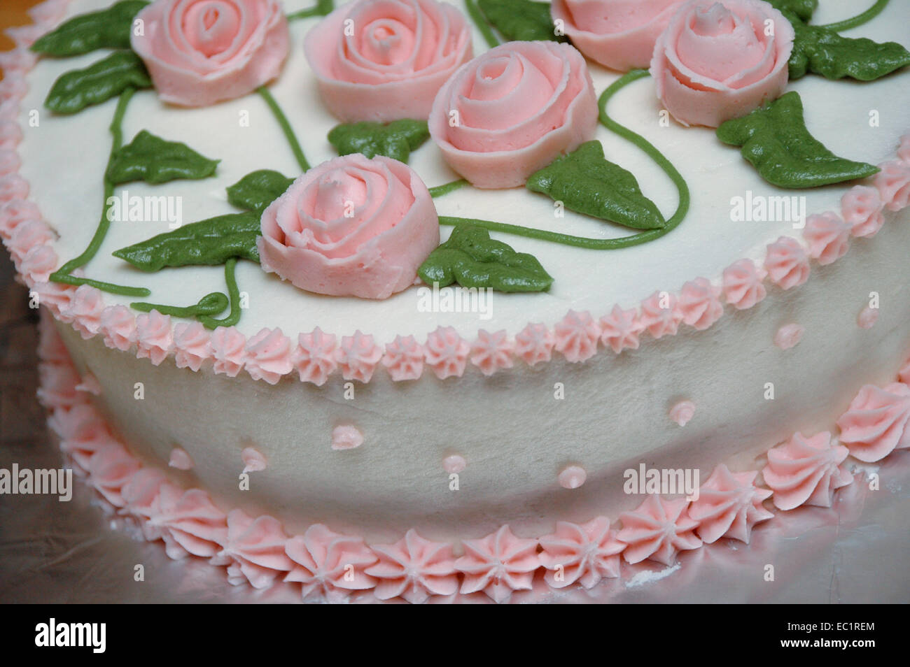 Detail of a cake with icing, icing flowers and leaves. Stock Photo