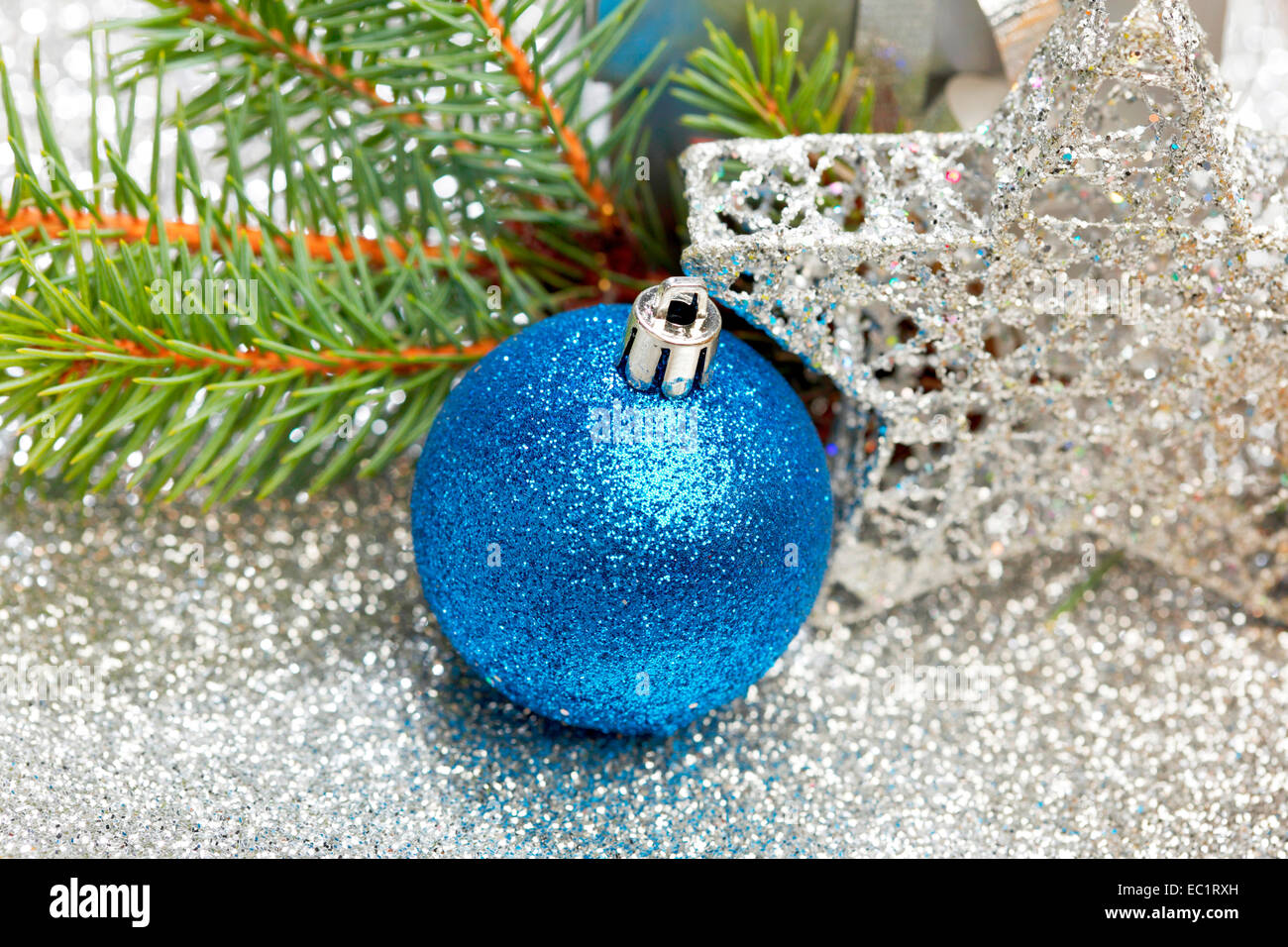 Christmas fir tree branch and decoration on silver glitter background ...