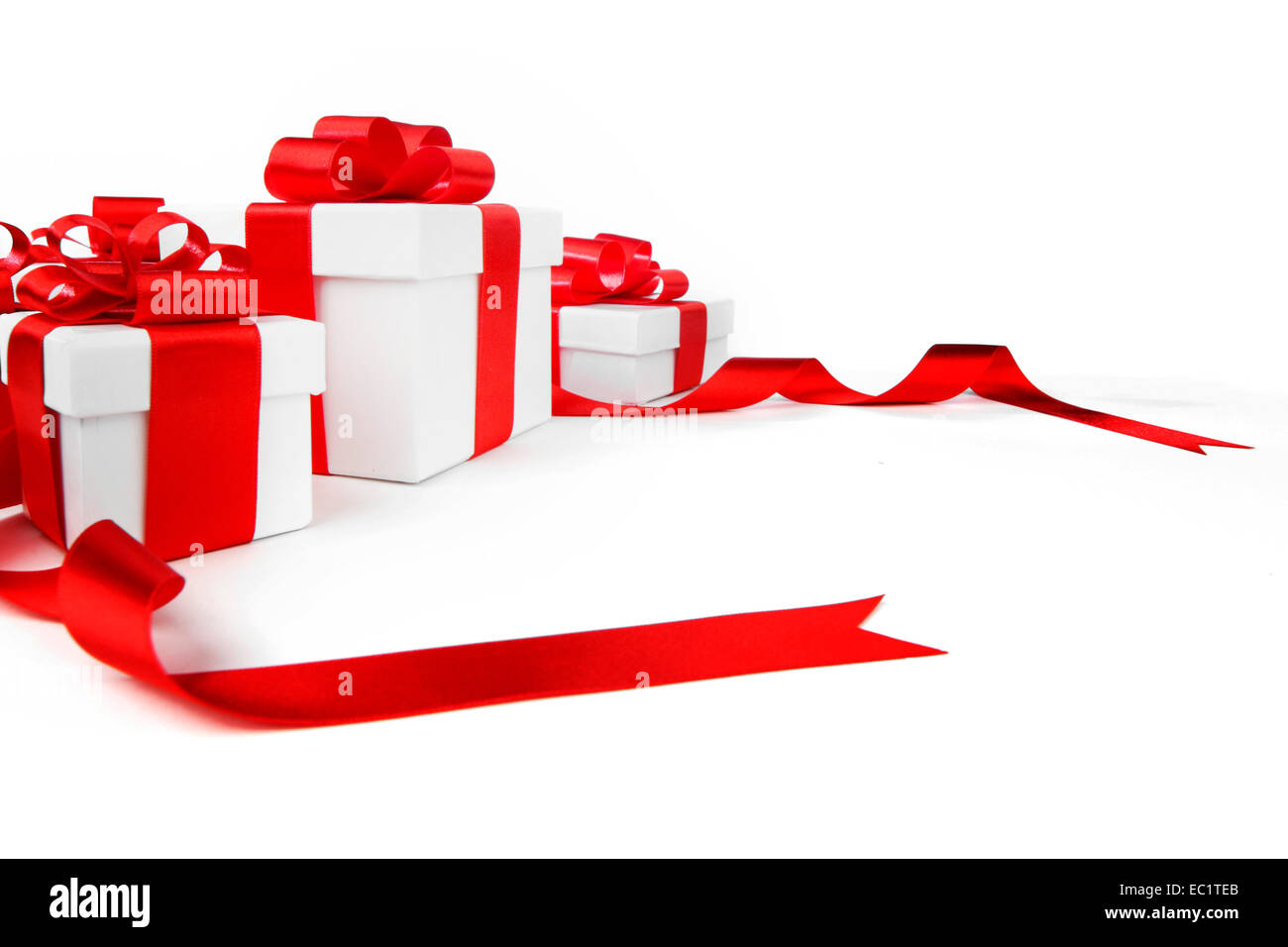 White gift boxes with red ribbon bows isolated on white background
