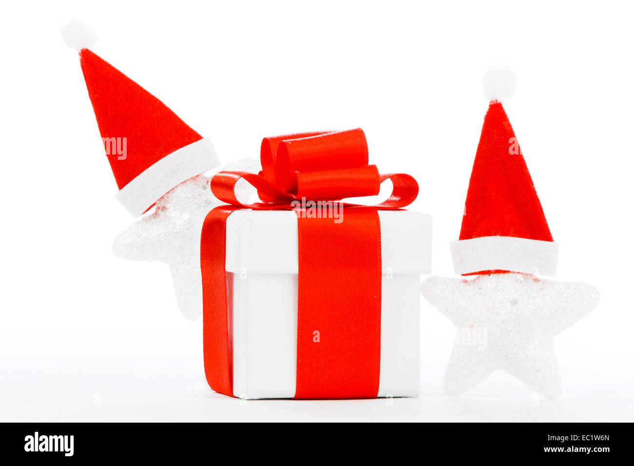 White gift box with red ribbon, stars with santa claus hats isolated on ...