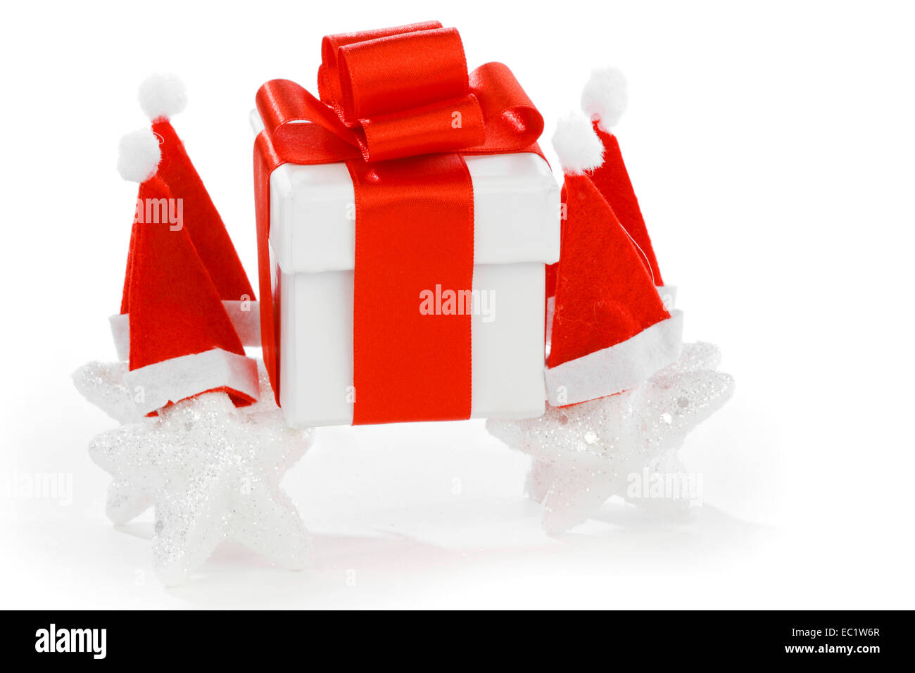 White gift box with red ribbon, stars with santa claus hats isolated on ...