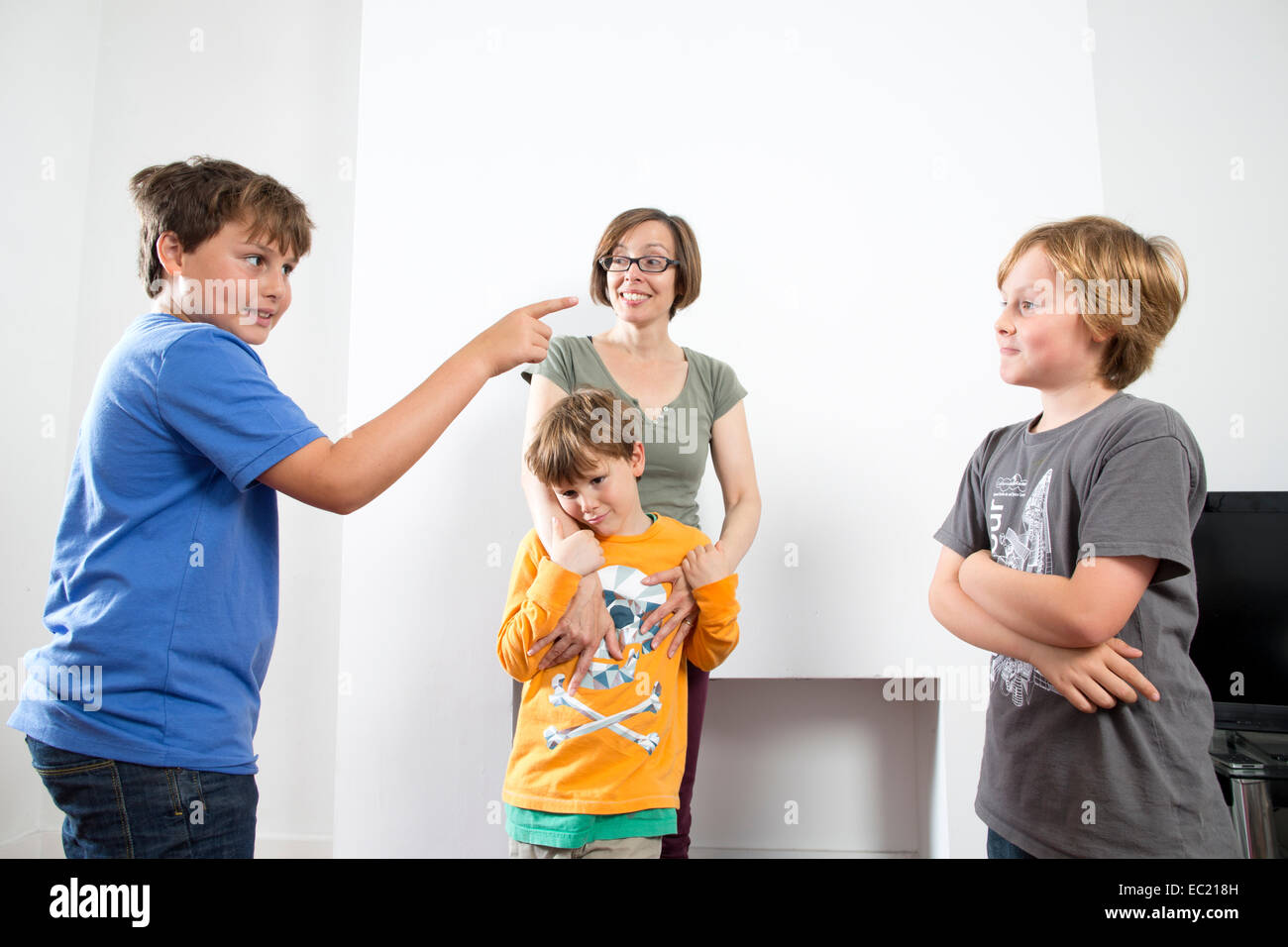 A mother trying to break up her children fighting at home Stock Photo