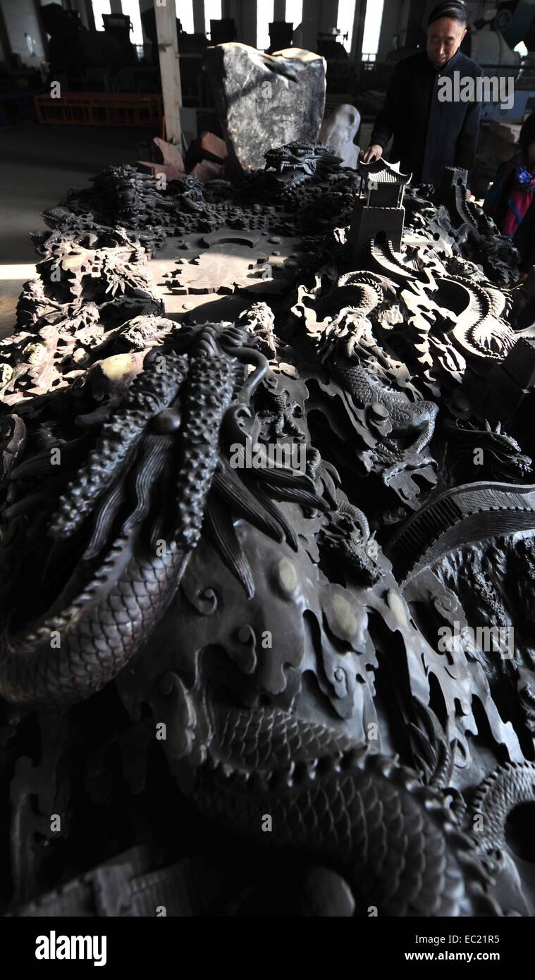 Shijiazhuang. 8th Dec, 2014. Photo taken on Dec. 8, 2014 shows a six-meter-long inkstone weighing about 18 tons in Shijiazhuang, north China's Hebei Province. A total of 56 dragons, featuring 56 ethnic groups in China, were engraved on the oval-shaped inkstone. © Wang Xiao/Xinhua/Alamy Live News Stock Photo