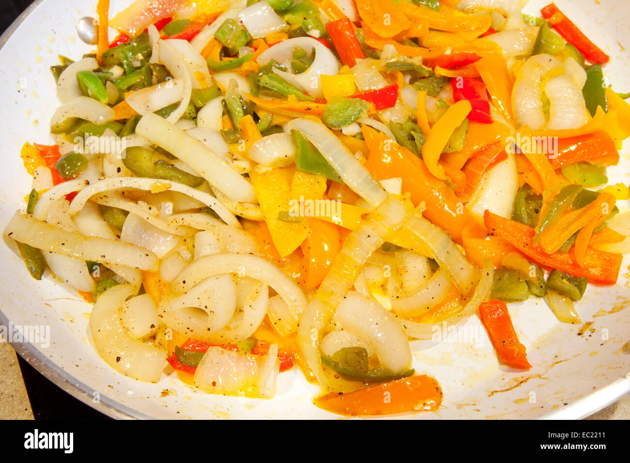 Caramelized onions and bell peppers in a skillet Stock Photo Alamy