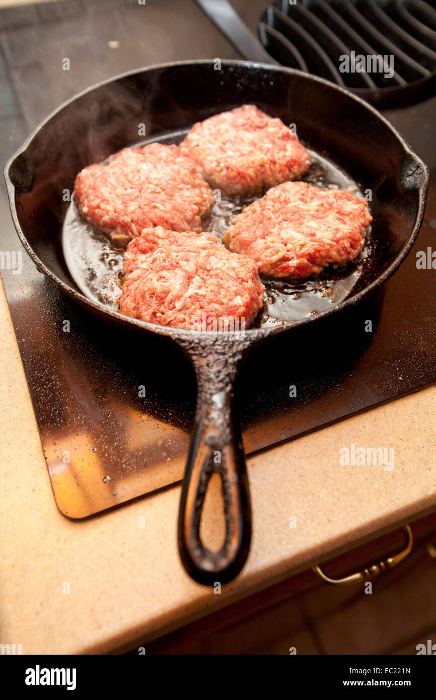 https://c8.alamy.com/comp/EC221N/hot-sausage-patties-cooking-in-a-black-cast-iron-skillet-on-a-stove-EC221N.jpg