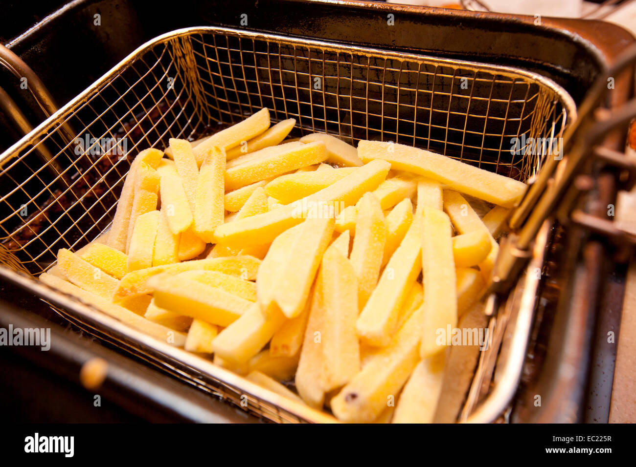 Cooking french fries in a deep fryer basket Stock Photo Alamy
