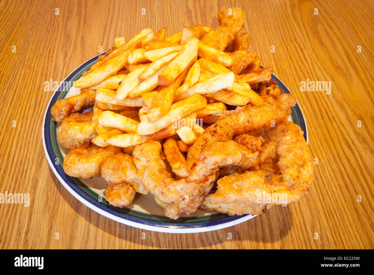 A heaping plate of fried chicken tenders and french fries Stock Photo