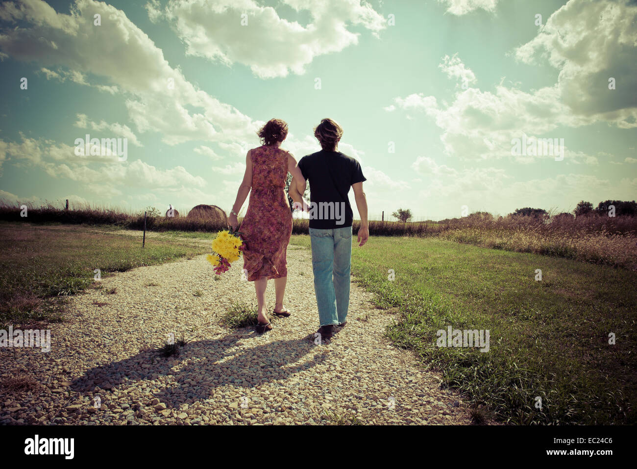 Couple walking hand in hand outside in country Stock Photo