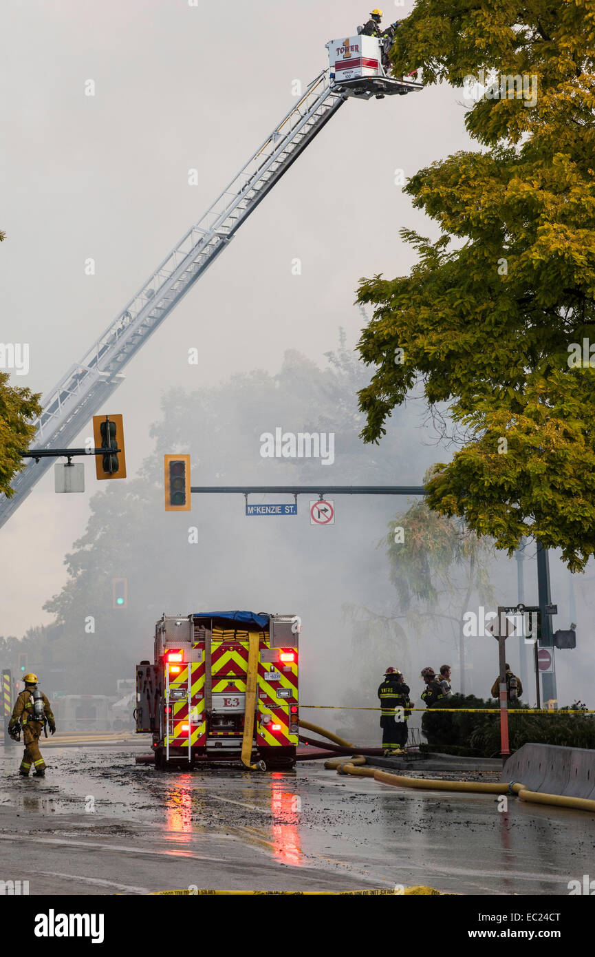 Fire fighters and emergency fire vehicles responding to a fire. Stock Photo