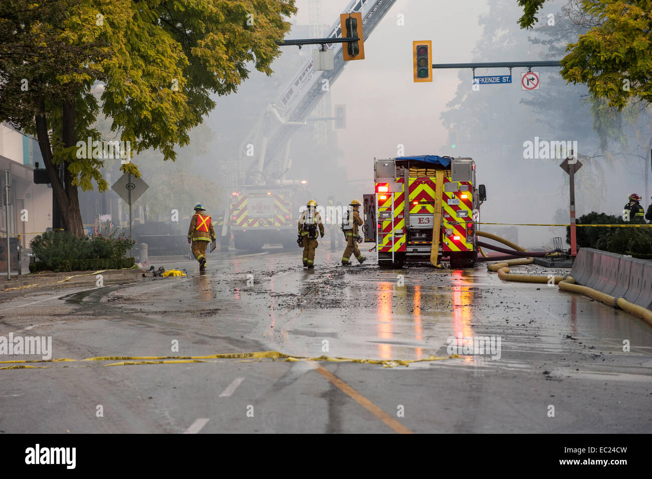 Firemen and emergency fire vehicles responding to a fire. Stock Photo