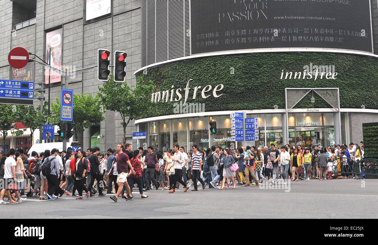 pedestrians crossing a street, Innisfree boutique, Shanghai China Stock Photo