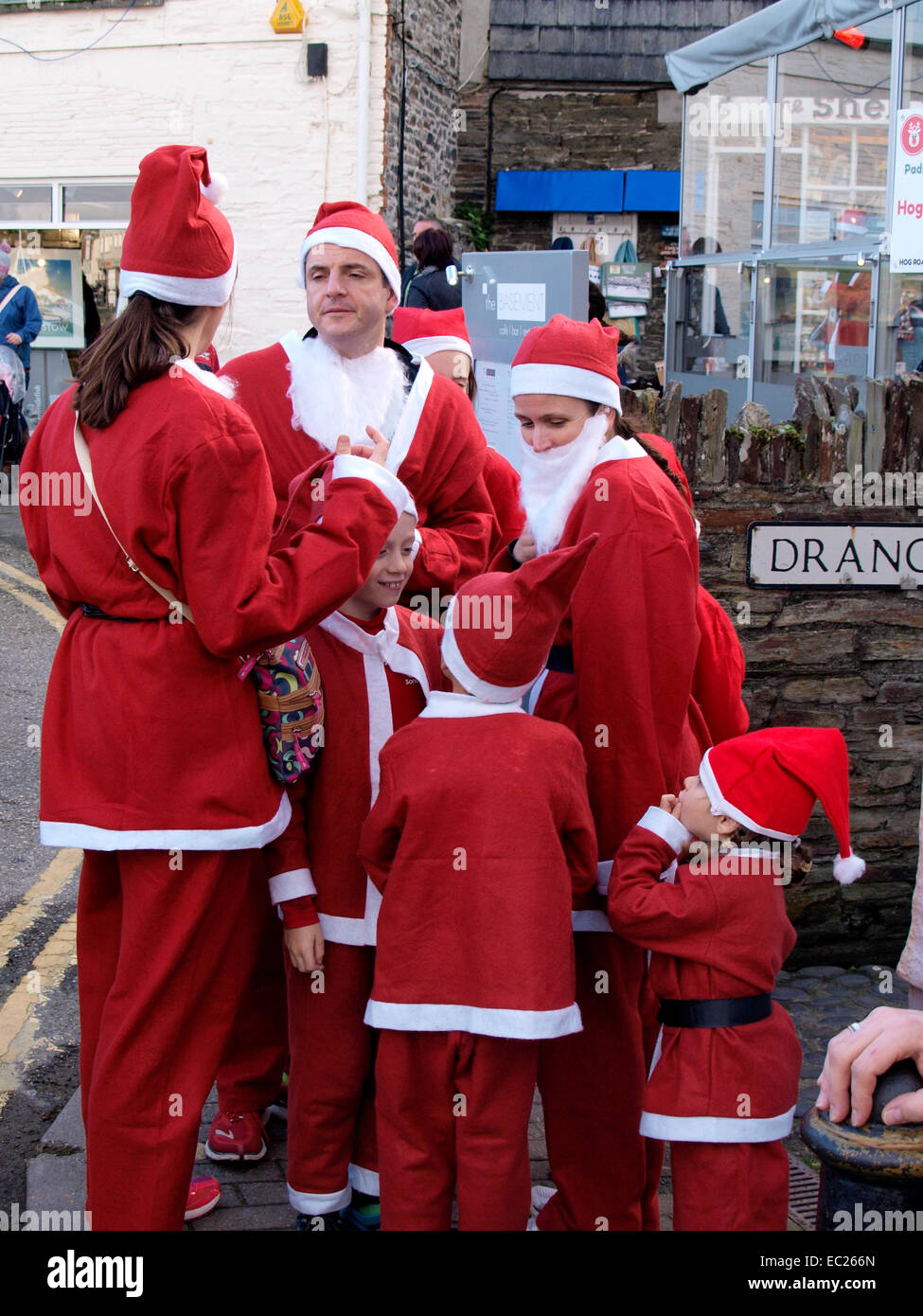 Family all dressed in Santa suits for the charity Santa run at the Padstow Christmas festival, Cornwall, UK Stock Photo