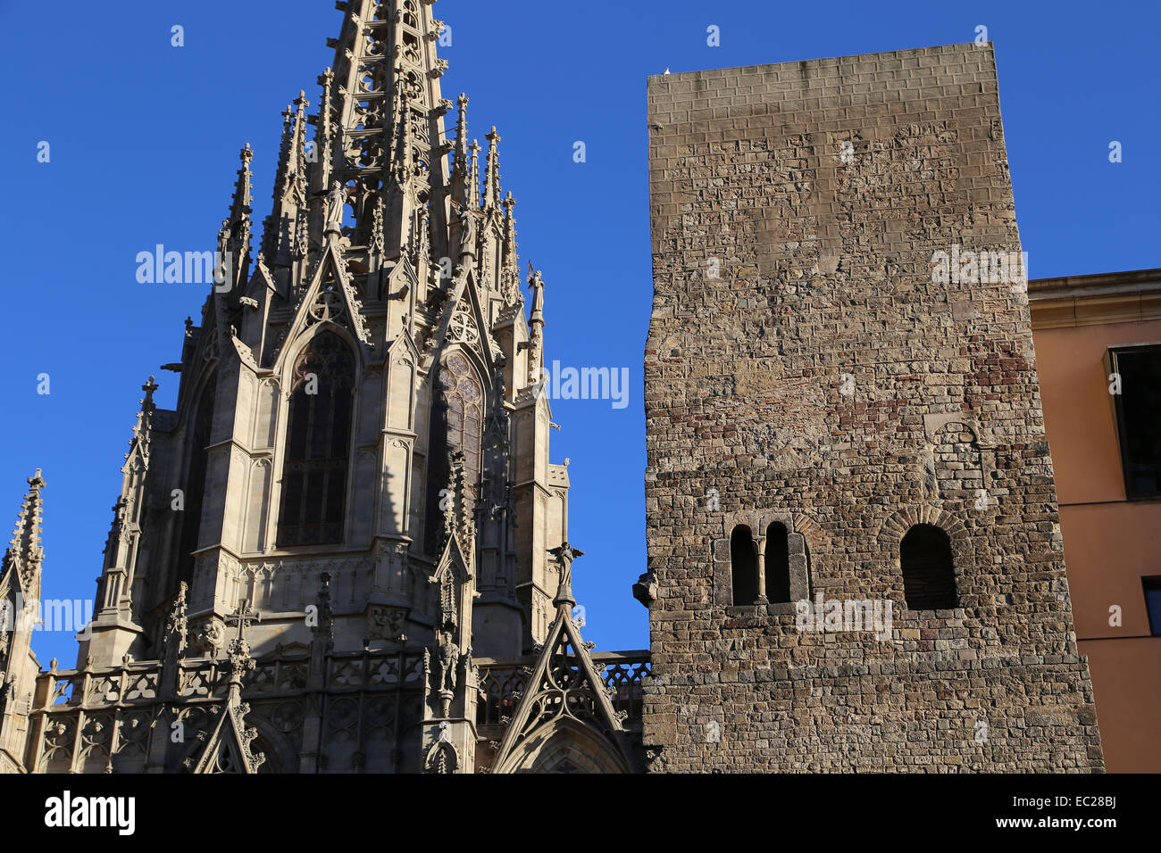 Spain. Catalonia. Barcelona. Tower from the second roman city wall (3rd-4th century) and facade Neo-Gothic of  Cathedral. Stock Photo