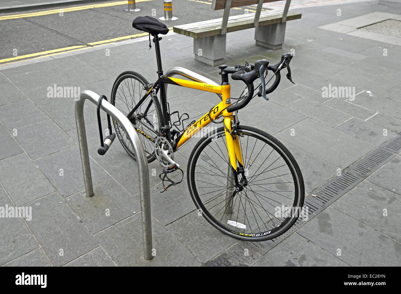 Yellow, Carrera racing bicycle locked to security hoop. Stock Photo