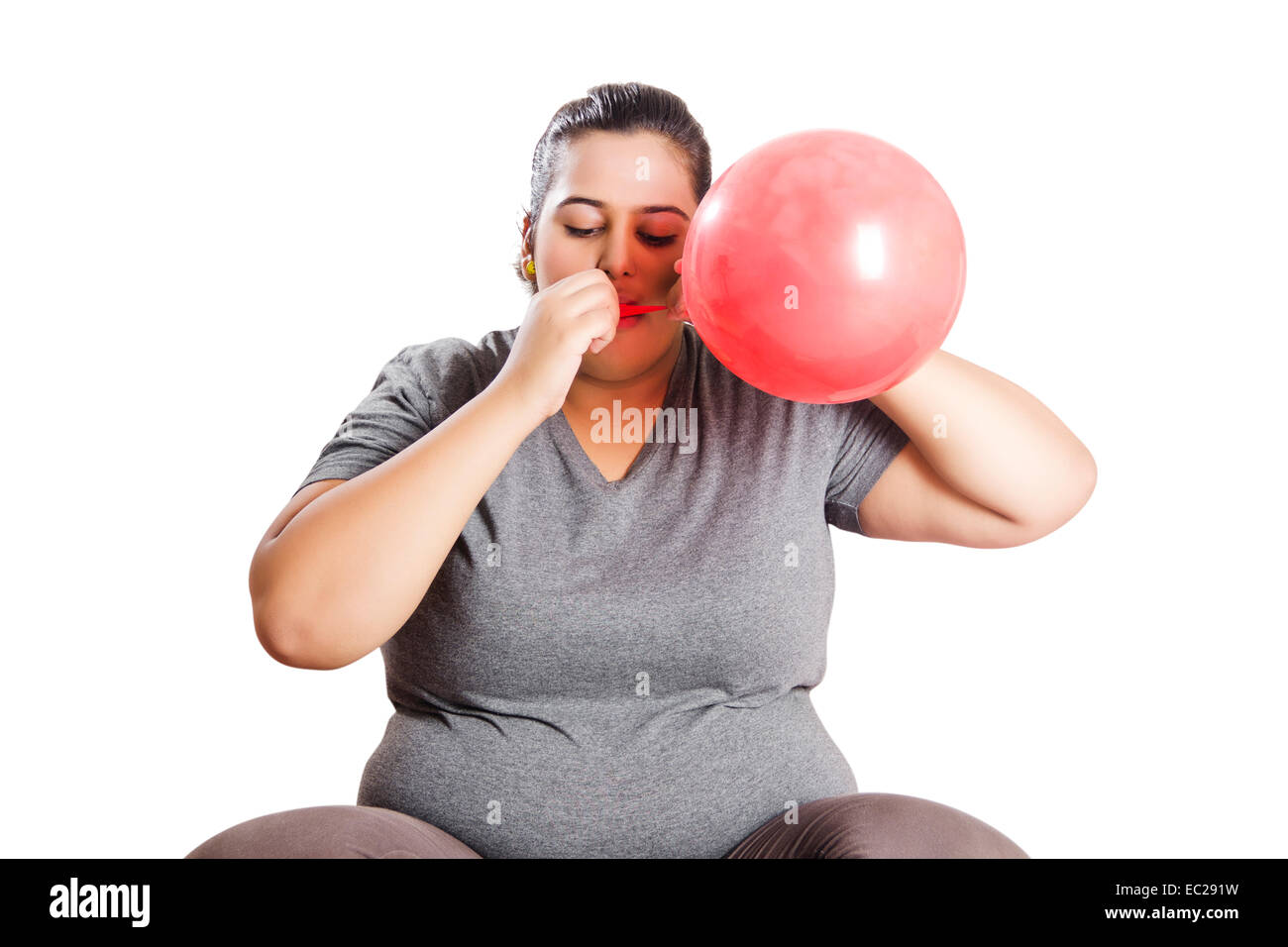 indian Obese  Lady Blowing Balloon Stock Photo