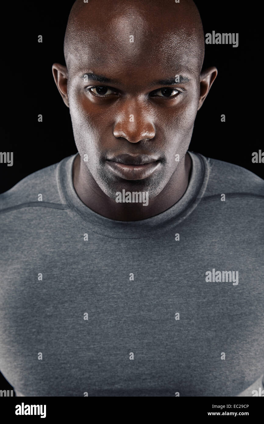 Close-up portrait of confident young African man against black background Stock Photo