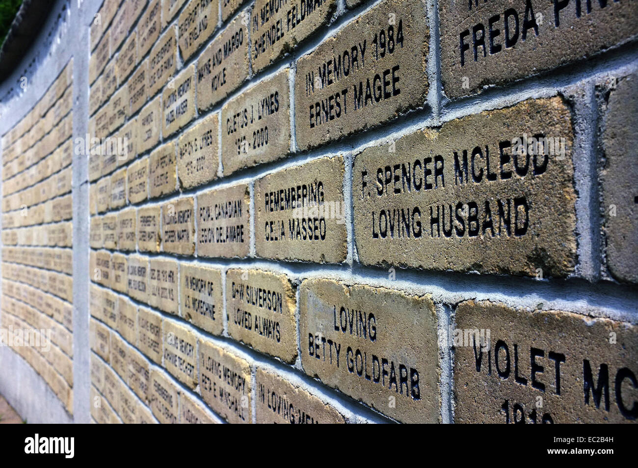 A wall of bricks with words carved on to them. Stock Photo