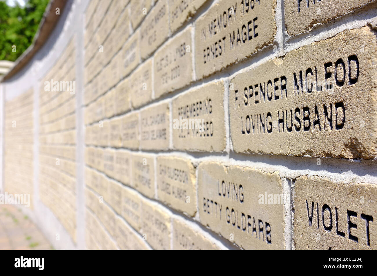 A wall of bricks with words carved on to them. Stock Photo