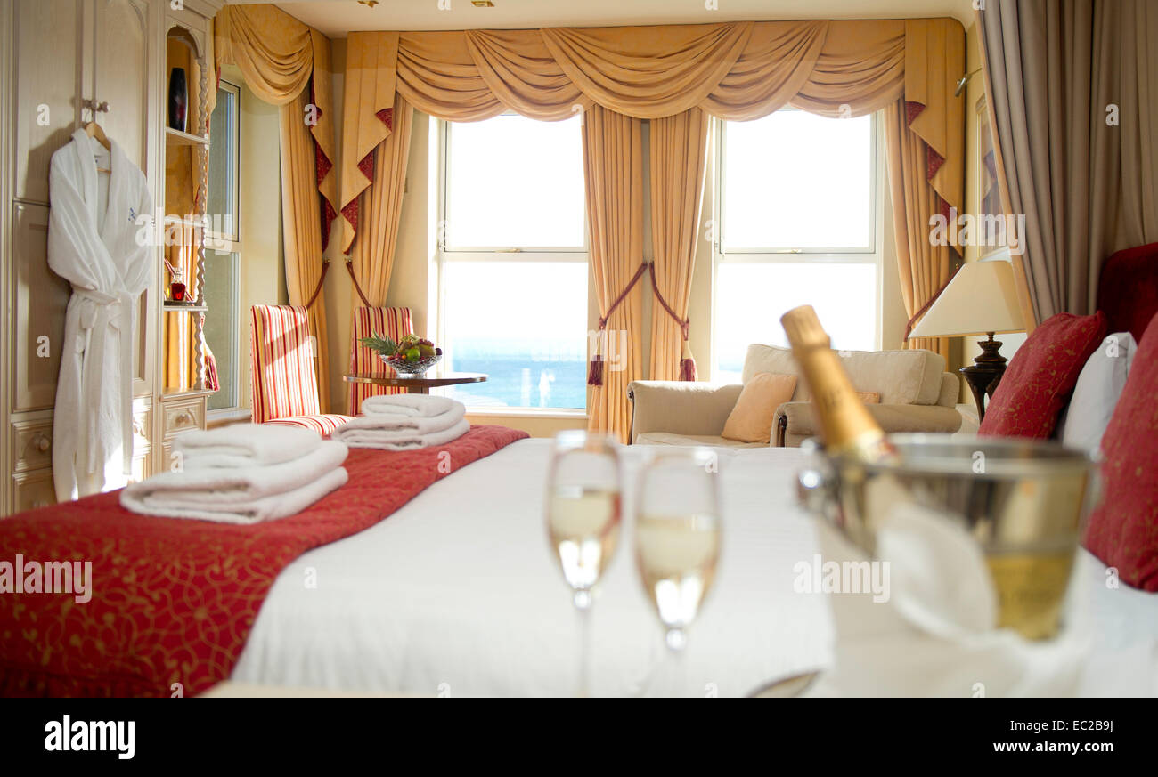 A luxury hotel room with a sea view and champagne and glasses in the
