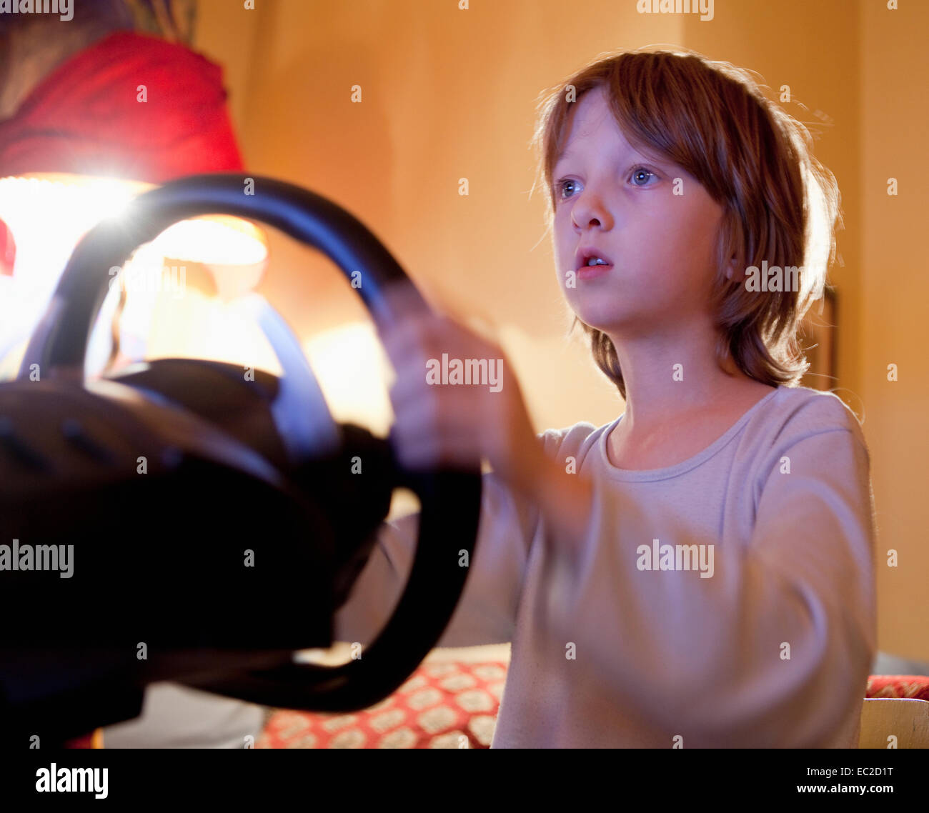 Boy Playing Racing Console Game with Steering Wheel Stock Photo