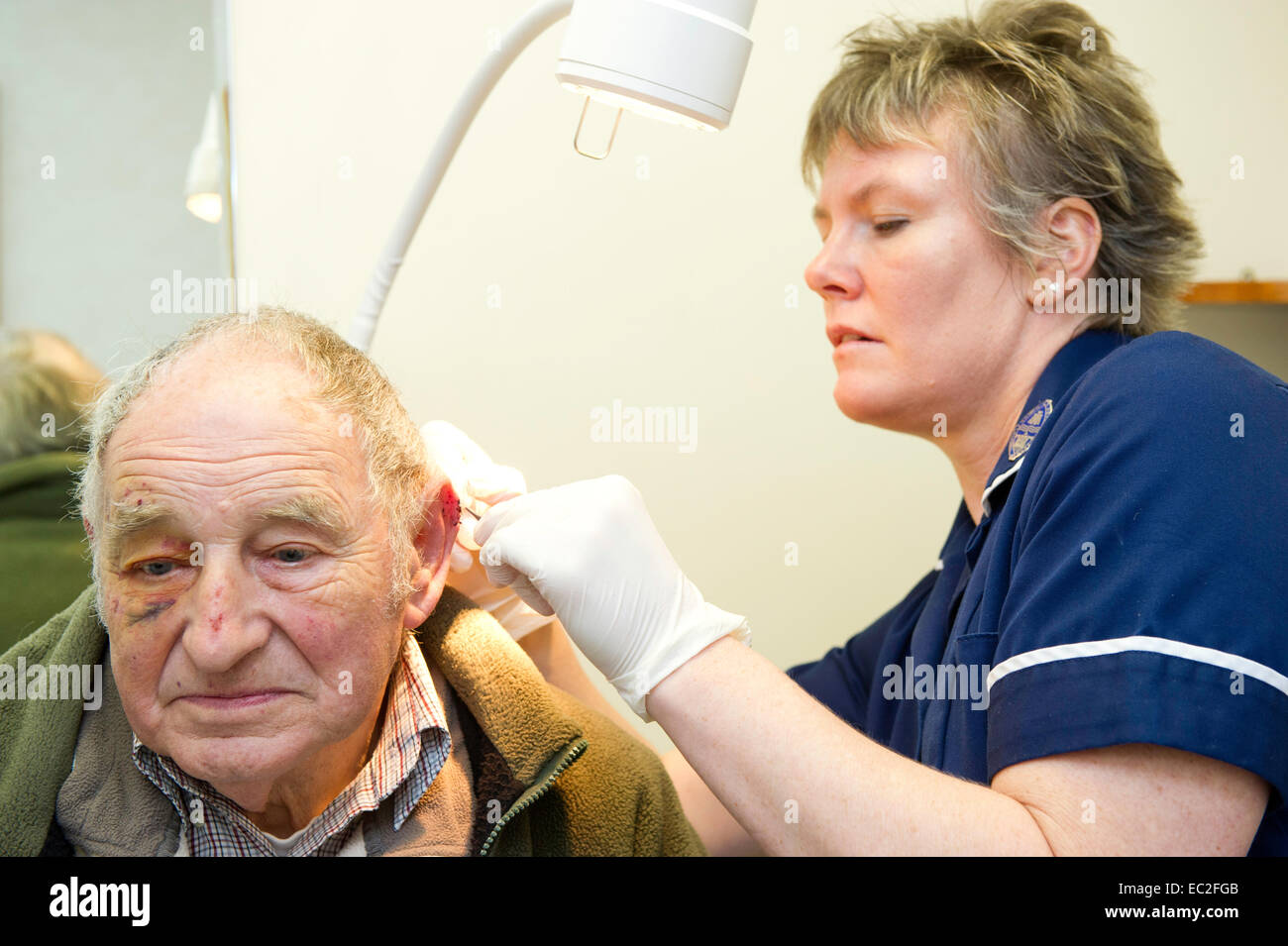 An NHS nurse examining a patient at a medical centre center Stock Photo