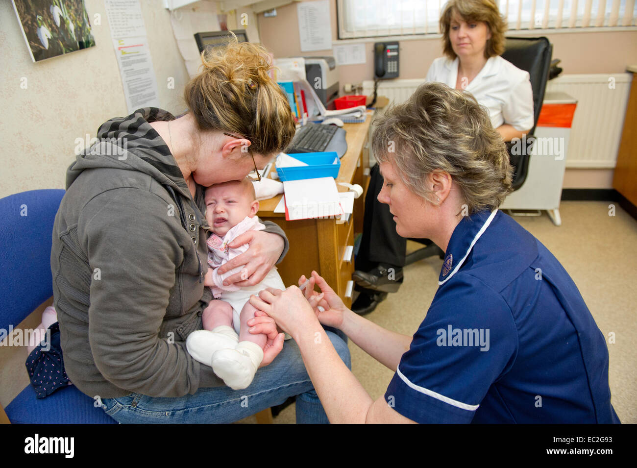 An NHS nurse examining a patient at a medical centre center Stock Photo