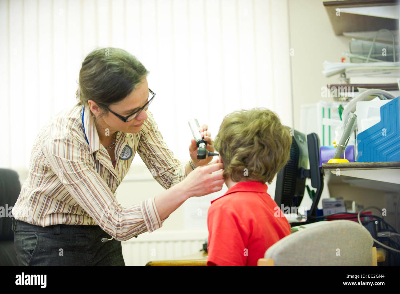 A female doctor talking to a young patient in a doctors surgery Stock Photo