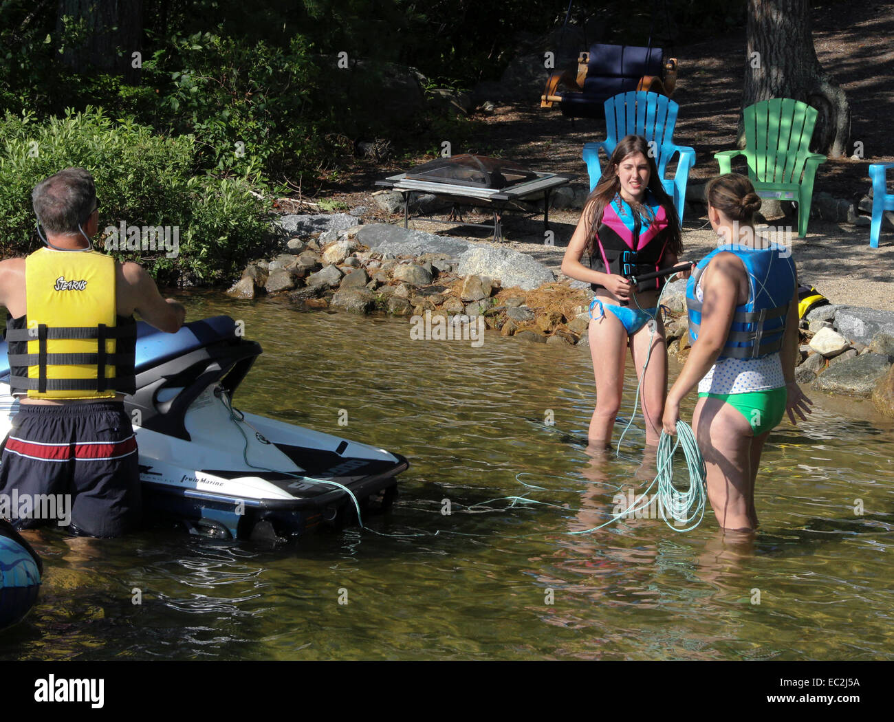 Young girls in bikinis and life vests getting ready to water ski. Stock Photo
