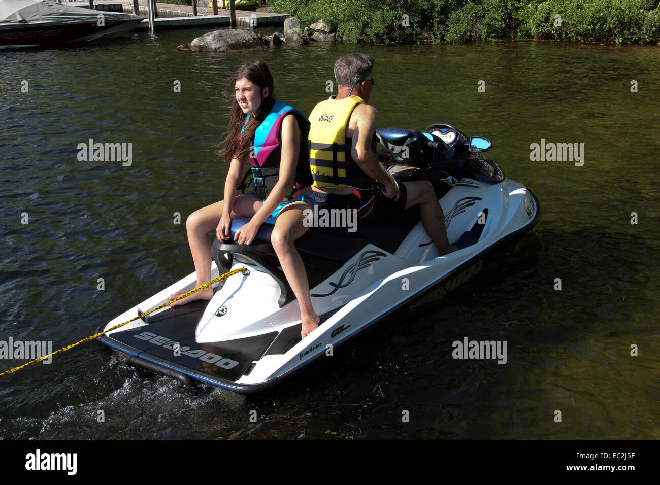 A sea doo set up for towing a skier. Driver and safety spotter Stock