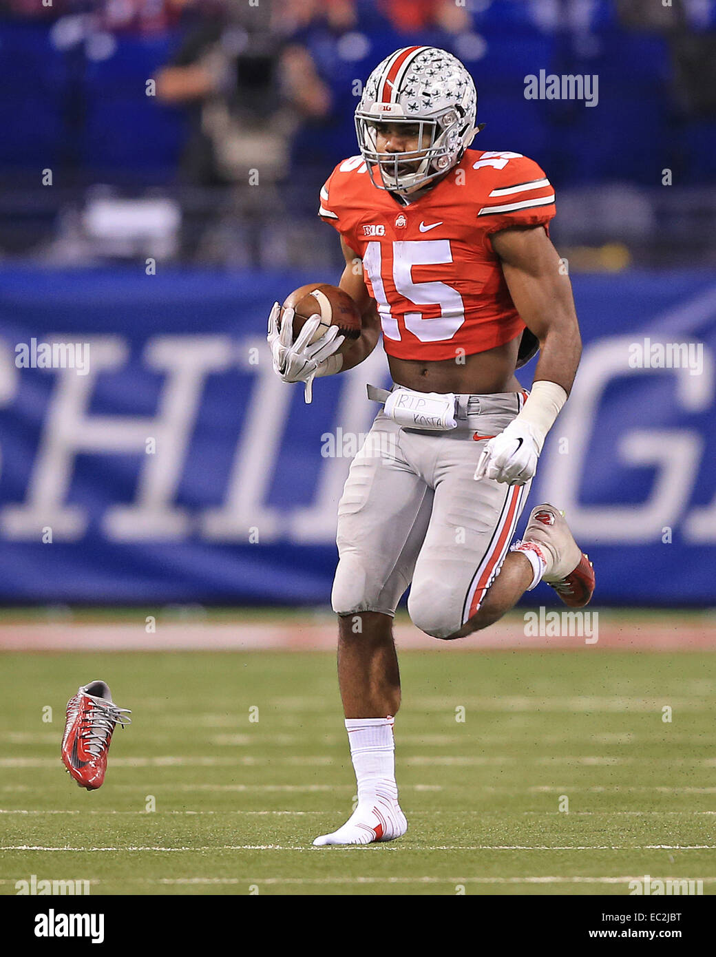 Indianapolis, IN, USA. 06th Dec, 2014. Ohio State Buckeyes running back Ezekiel Elliott (15) loses his shoe as he breaks free from Wisconsin defenders for a 60 yard run during the second half of the NCAA Big 10 Championship football game between the Wisconsin Badgers and the Ohio State Buckeyes at Lucas Oil Stadium in Indianapolis, Indiana. Ohio State defeated Wisconsin 59-0. ©2014 Billy Hurst/CSM/Alamy Live News Stock Photo