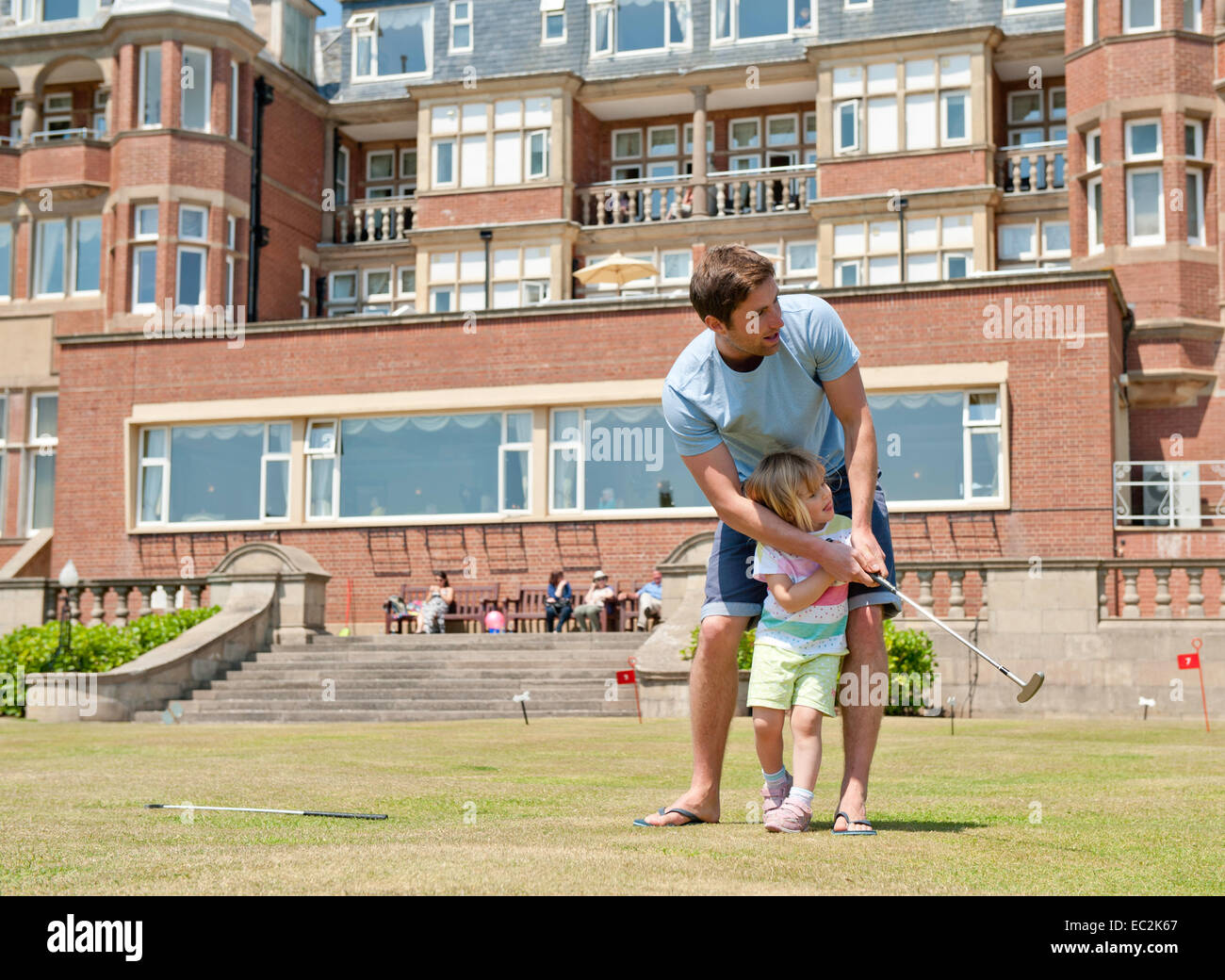 A father teaching his child to play golf Stock Photo