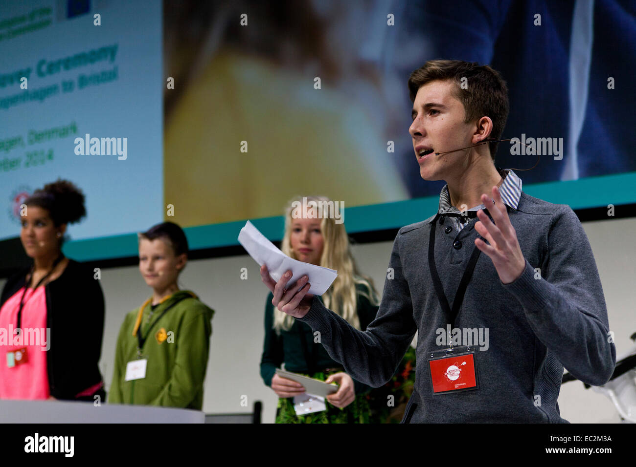 Copenhagen, Denmark. 8th December, 2014. Young people from  the 'Childrens Climate Summit” is on the stage during the European Green Capital 2014 meeting in Copenhagen.  Each of them explains to the delegates and politicians what they expects  and demands of the future in order to achieve a good and sustainable living. Speaking at the photo (right) is James Gibson from Bristol, UK. Next to him is Siw Ronne Appel (Denmark), Jonas Balsby (Belgium) and Aliyah Bergstrom (Sweden).  Credit:  OJPHOTOS/Alamy Live News Stock Photo