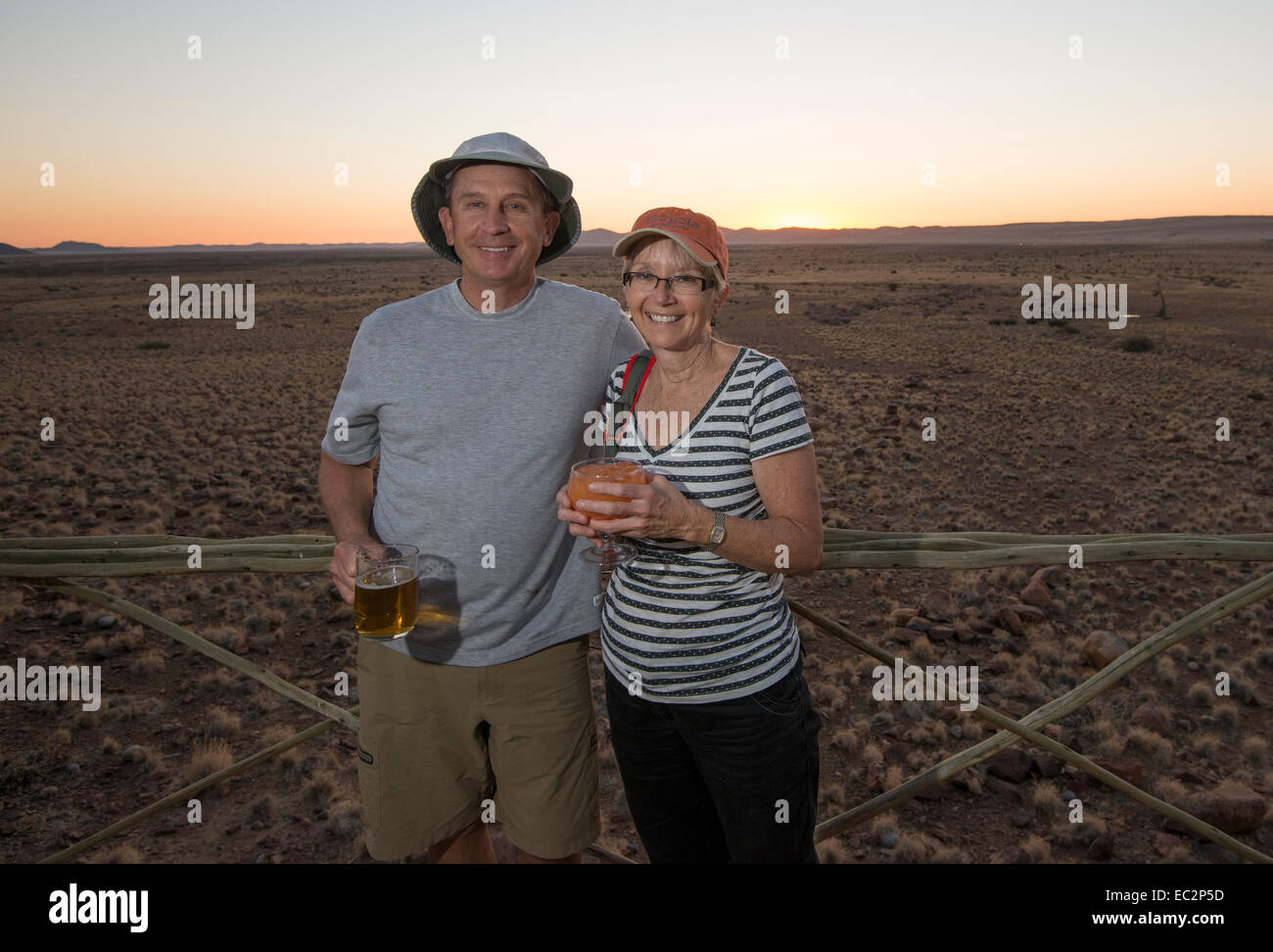 Africa, Namibia. Sossus Dune Lodge.  Namibia Desert. Sossusvlei, Naukluft Park. Happy couple enjoying sunset. Model Released. Stock Photo