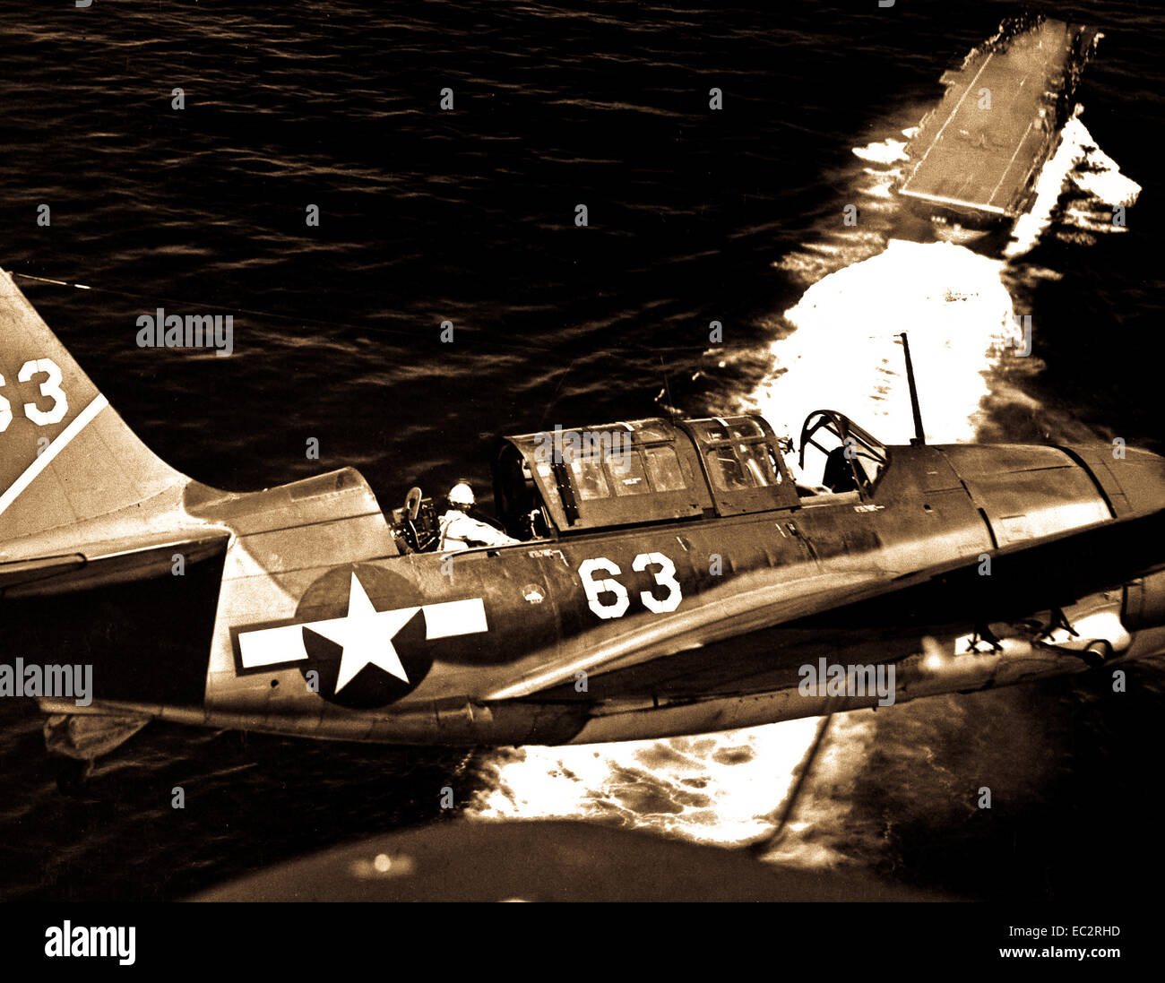Aerial view of SB2C in upper landing circle showing USS YORKTOWN, below.  July 1944.  (Navy) Stock Photo
